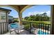 Balcony with seating and pool view overlooking verdant golf course at 1228 Castle Pines Ct, Reunion, FL 34747