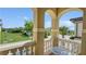 Balcony with an ornamental table and chairs overlooks a grassy lawn at 1228 Castle Pines Ct, Reunion, FL 34747