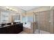 Bathroom with double vanity, soaking tub, and glass-enclosed shower at 1228 Castle Pines Ct, Reunion, FL 34747
