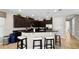 Kitchen with dark cabinets, granite countertops, an island with seating, and modern stainless steel appliances at 1228 Castle Pines Ct, Reunion, FL 34747