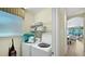Bright laundry room with washer, dryer, shelving, and convenient access to the pool at 1228 Castle Pines Ct, Reunion, FL 34747