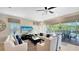 Bright living room featuring two sofas, two armchairs, a ceiling fan, and sliding doors to the pool area at 1228 Castle Pines Ct, Reunion, FL 34747