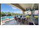 A spacious patio with outdoor dining set, ceiling fan, and pool view offers great space for entertainment at 1228 Castle Pines Ct, Reunion, FL 34747