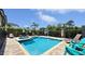 Inviting pool and spa area surrounded by lush greenery and lounge chairs, perfect for relaxation and recreation at 1228 Castle Pines Ct, Reunion, FL 34747
