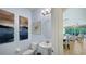 Stylish powder room with pedestal sink, decorative wall art, and access to the pool area at 1228 Castle Pines Ct, Reunion, FL 34747