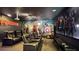 Home theater room with tiered seating, large screen, projector, and themed wall mural for entertainment at 1228 Castle Pines Ct, Reunion, FL 34747