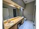 Bathroom featuring a long vanity, double sinks, and a well-lit mirror at 13940 Corrine Key Pl, Orlando, FL 32824