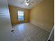 Cozy bedroom featuring tile floors and a window offering natural light at 13940 Corrine Key Pl, Orlando, FL 32824