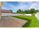 A well-maintained backyard featuring a concrete patio, green grass, and white fencing at 1425 Carey Glen Cir, Orlando, FL 32824