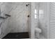 Modern bathroom featuring black and white marble-tiled walls, and a toilet with a window at 1425 Carey Glen Cir, Orlando, FL 32824