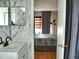 Bright bathroom with marble tiled wall, modern vanity, and view into bedroom at 1425 Carey Glen Cir, Orlando, FL 32824