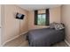 Cozy bedroom with grey comforter, natural light, and a wall-mounted TV at 1425 Carey Glen Cir, Orlando, FL 32824
