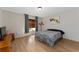 Neutral bedroom with hardwood floors, window with blinds, and a dark patterned bedspread at 1425 Carey Glen Cir, Orlando, FL 32824