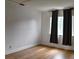 Bedroom with wood floors, two windows, dark drapes, and white baseboards at 1425 Carey Glen Cir, Orlando, FL 32824