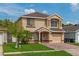Charming two-story home with a well-manicured lawn, brick driveway, and inviting entrance at 1425 Carey Glen Cir, Orlando, FL 32824