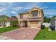 Inviting two-story home with a brick driveway and attached one car garage at 1425 Carey Glen Cir, Orlando, FL 32824