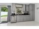 Kitchen featuring gray cabinets, stainless steel appliances, and access to backyard at 1425 Carey Glen Cir, Orlando, FL 32824
