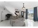 Bright living room with gray sofa, white tile floors, and large window at 1425 Carey Glen Cir, Orlando, FL 32824