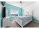 Bright bedroom with large windows, ceiling fan, light blue accent wall, and a comfortable queen-size bed at 14309 Lanikai Beach Dr, Orlando, FL 32827