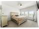 Bedroom with a ceiling fan, neutral carpet and paint, and a gold upholstered queen-size bed at 14309 Lanikai Beach Dr, Orlando, FL 32827