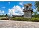 Striking entrance to Isles of Lake Nona with stone tower, lush landscaping and water feature at 14309 Lanikai Beach Dr, Orlando, FL 32827