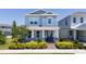 Beautiful two-story home with a covered porch, decorative columns, and lush landscaping in a residential area at 14309 Lanikai Beach Dr, Orlando, FL 32827