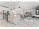 Open-concept kitchen with stainless steel appliances, white cabinets, marble floors, and a spacious island at 14309 Lanikai Beach Dr, Orlando, FL 32827