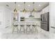 Bright kitchen features stainless steel appliances, white cabinets, island with seating, and marble floors at 14309 Lanikai Beach Dr, Orlando, FL 32827