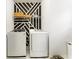 Modern laundry room with black and white accent wall, front-loading washer and dryer and decorative shelving at 14309 Lanikai Beach Dr, Orlando, FL 32827