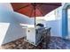 Outdoor kitchen bar area features a built in grill and bar seating beneath an umbrella at 14309 Lanikai Beach Dr, Orlando, FL 32827