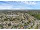 Overhead perspective of a charming community featuring tree-lined streets and a tranquil lake at 1436 Nolton Way, Orlando, FL 32822