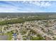 Expansive aerial view of a neighborhood with mature trees and well-maintained homes under a partly cloudy sky at 1436 Nolton Way, Orlando, FL 32822