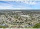 Aerial view featuring a serene lake surrounded by well-kept homes with lush landscaping under a partly cloudy sky at 1436 Nolton Way, Orlando, FL 32822