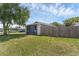 A view of a home's exterior featuring a wooden fence and a green lawn at 1436 Nolton Way, Orlando, FL 32822