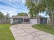 Charming single-story home with a cracked circular driveway, lush lawn, and a two-car garage at 1436 Nolton Way, Orlando, FL 32822
