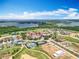 Serene aerial view of a luxury community featuring tennis courts, lake views and beautiful Mediterranean-style homes at 15121 Pendio Dr, Montverde, FL 34756