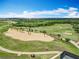 Picturesque aerial view of a golf course with sprawling green fairways and a scenic backdrop of lakes and woodlands at 15121 Pendio Dr, Montverde, FL 34756