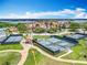 Scenic aerial view of tennis courts and a community featuring well-maintained landscaping near a picturesque lake at 15121 Pendio Dr, Montverde, FL 34756