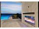 Backyard featuring an outdoor fireplace and pool, perfect for relaxation and entertaining with waterfront view at 15121 Pendio Dr, Montverde, FL 34756