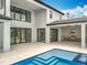 Luxury backyard with covered patio featuring outdoor kitchen, seamlessly blending indoor and outdoor living by the pool at 15121 Pendio Dr, Montverde, FL 34756