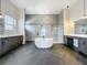 Modern bathroom with freestanding tub, walk-in shower, herringbone tile floors, double sink vanity, and pendant lighting at 15121 Pendio Dr, Montverde, FL 34756