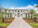 Striking modern home with a grand entrance, complemented by manicured landscaping and a paved driveway at 15121 Pendio Dr, Montverde, FL 34756