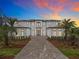 Elegant home featuring meticulous landscaping, a paved driveway, and exterior lighting creating an inviting and luxurious ambiance at 15121 Pendio Dr, Montverde, FL 34756