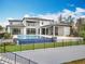 Exterior view of the house featuring an amazing in-ground swimming pool and lush backyard at 15121 Pendio Dr, Montverde, FL 34756