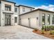 Contemporary home with a crisp white exterior, black accents, and a well-manicured yard enhances curb appeal at 15121 Pendio Dr, Montverde, FL 34756