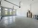 Spacious three car garage featuring epoxy flooring, windows for natural light, and high ceilings at 15121 Pendio Dr, Montverde, FL 34756