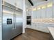 Modern kitchen with stainless steel refrigerator, custom cabinets, and chevron backsplash at 15121 Pendio Dr, Montverde, FL 34756