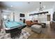 An open living space with a billiard table, modern lighting, and comfortable seating offers entertainment and relaxation at 15121 Pendio Dr, Montverde, FL 34756