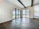 Open living area features a modern chandelier, dark hardwood floors and a wall of glass doors leading to the outdoor pool at 15121 Pendio Dr, Montverde, FL 34756