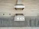 Close up of an outdoor kitchen with a stainless steel grill, granite countertop, and cabinetry at 15121 Pendio Dr, Montverde, FL 34756